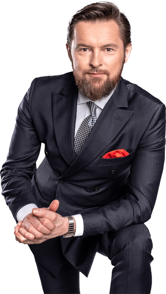 Wojciech S. Wocław w granatowym dwurzędowym garniturze
